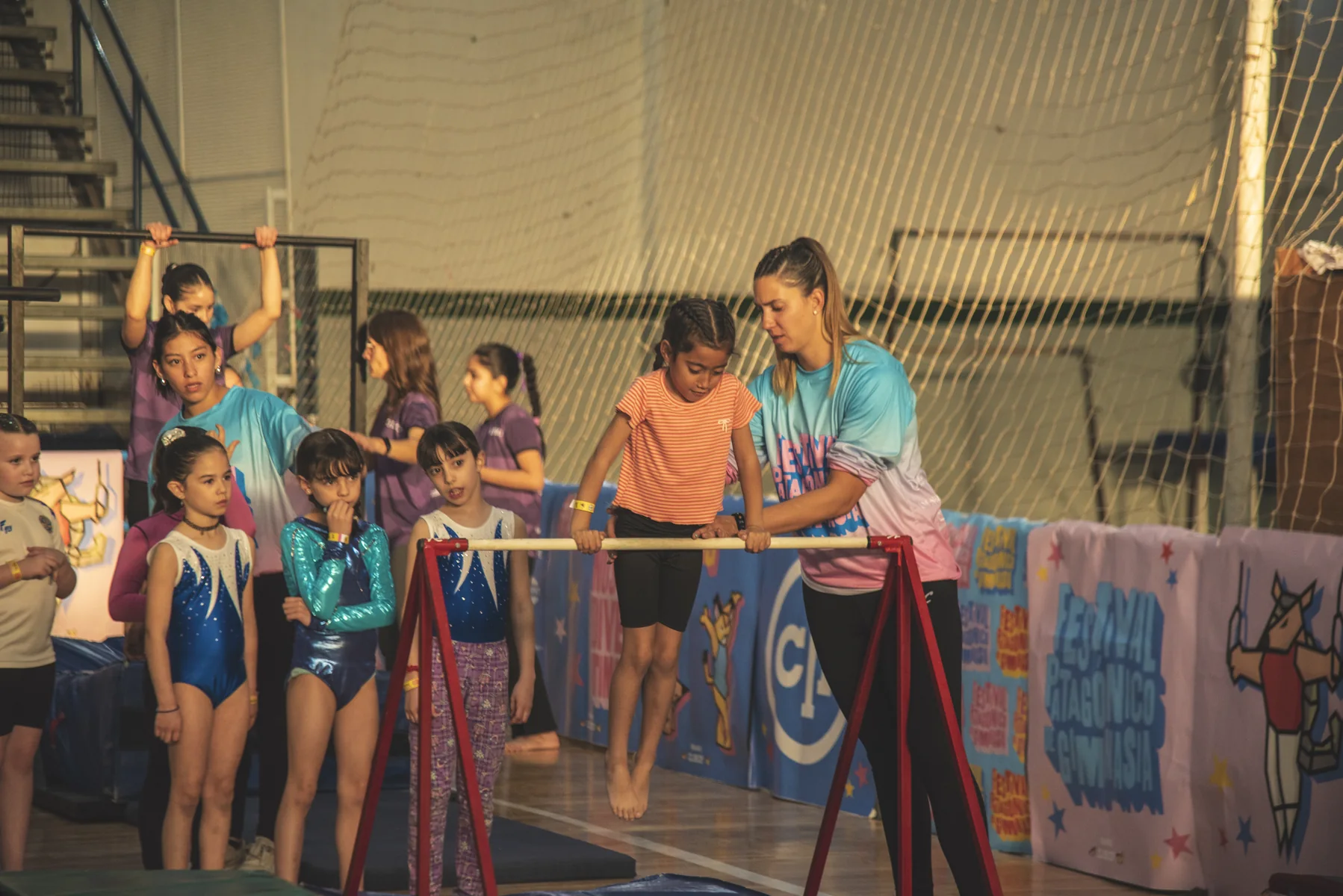 Entrenadora acompañando a gimnastas en el circuito de la edición 2025